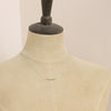 A mannequin wearing the peridot bar necklace
