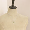 A mannequin wearing the peridot drop necklace