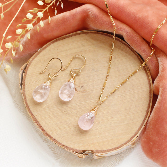 The morganite drop earrings styled with the matching necklace on wood with orange velvet and dried grass