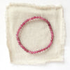 The pink tourmaline stretch bracelet styled on tan linen