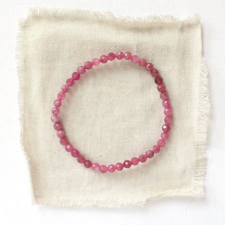 The pink tourmaline stretch bracelet styled on tan linen
