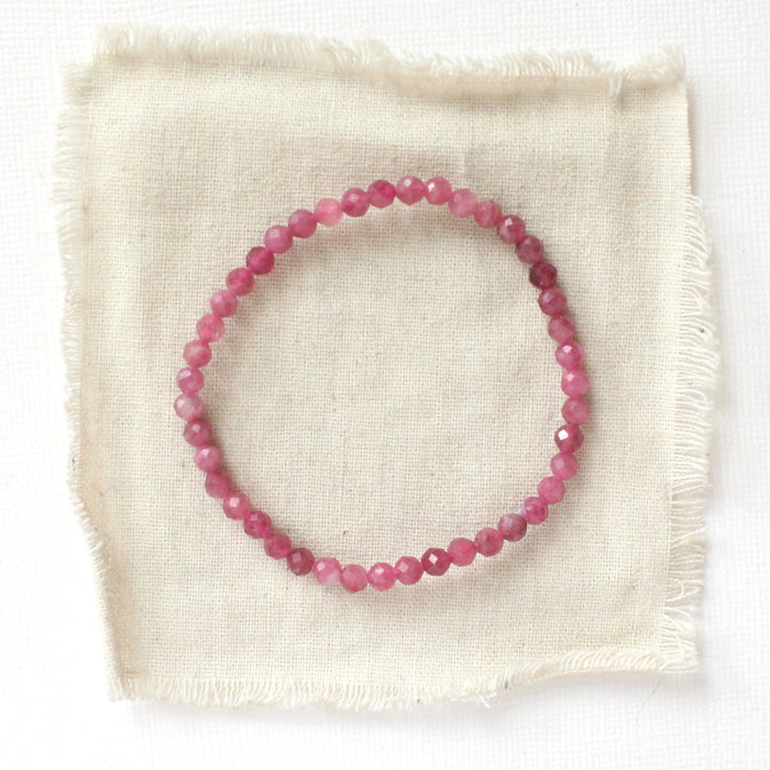 The pink tourmaline stretch bracelet styled on tan linen