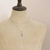 A mannequin wearing the pinned aquamarine gold necklace