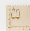 The pinned mythos earrings on a wooden ruler for size reference