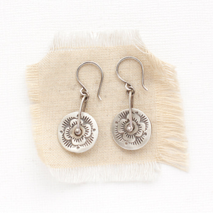 The pinned columbine disc earrings styled on tan linen