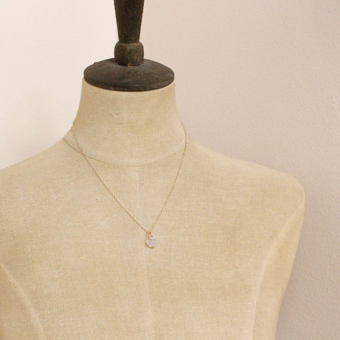 A mannequin wearing the pinned gold herkimer diamond necklace