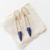 The pinned lapis spear earrings styled on tan linen