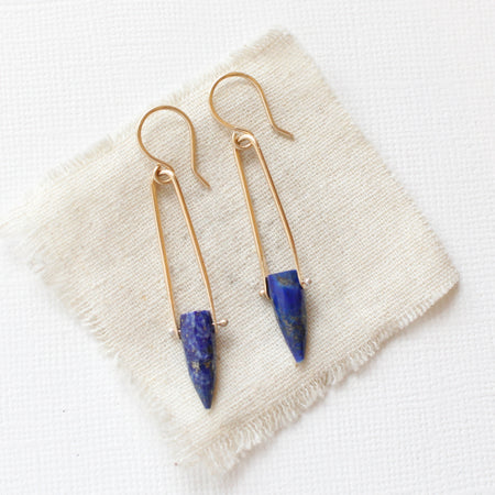 The pinned lapis spear earrings styled on tan linen