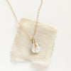 The pinned organic pearl necklace styled on tan linen