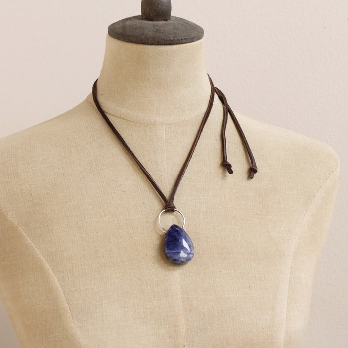 A mannequin wearing the pinned sodalite adjustable leather necklace to show the shorter length option