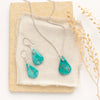 The pinned turquoise earrings styled on linen with the matching necklace and dried grass