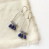 The pinned vinca arch earrings styled on tan linen