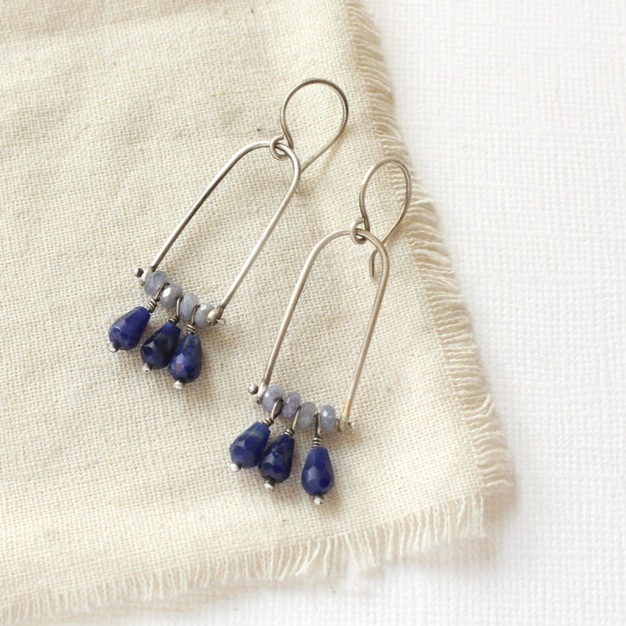 The pinned vinca arch earrings styled on tan linen