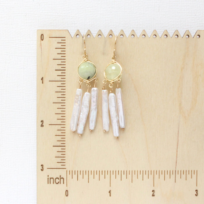 The prehnite and pearl earrings on a wooden ruler for size reference