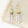 The prehnite and pearl chandelier earrings styled on tan linen