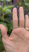 The thulite ring being worn on a hand