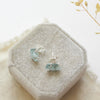 The prong set aquamarine earrings styled on a velvet box to show the posts and butterfly earbacks.