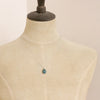 A mannequin wearing the prong set emerald necklace