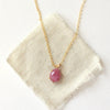 The prong set ruby necklace styled on tan linen