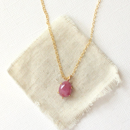 The prong set ruby necklace styled on tan linen