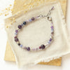 The purple haze gemstone bracelet styled on a tan rock with linen and dried grass