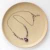 The purple rain necklace styled on a tan plate to show the adjustable lobster clasp closure