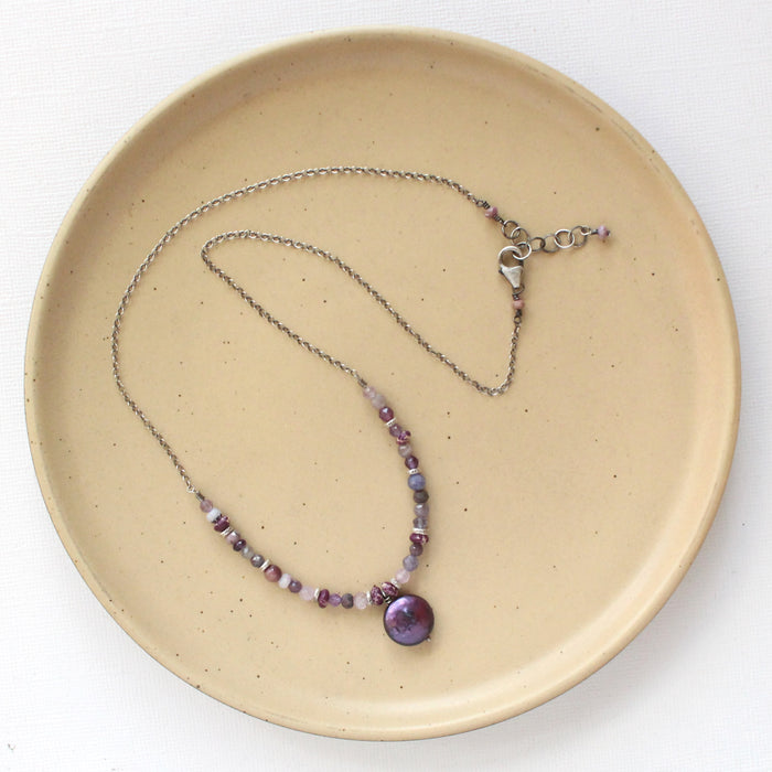 The purple rain necklace styled on a tan plate to show the adjustable lobster clasp closure