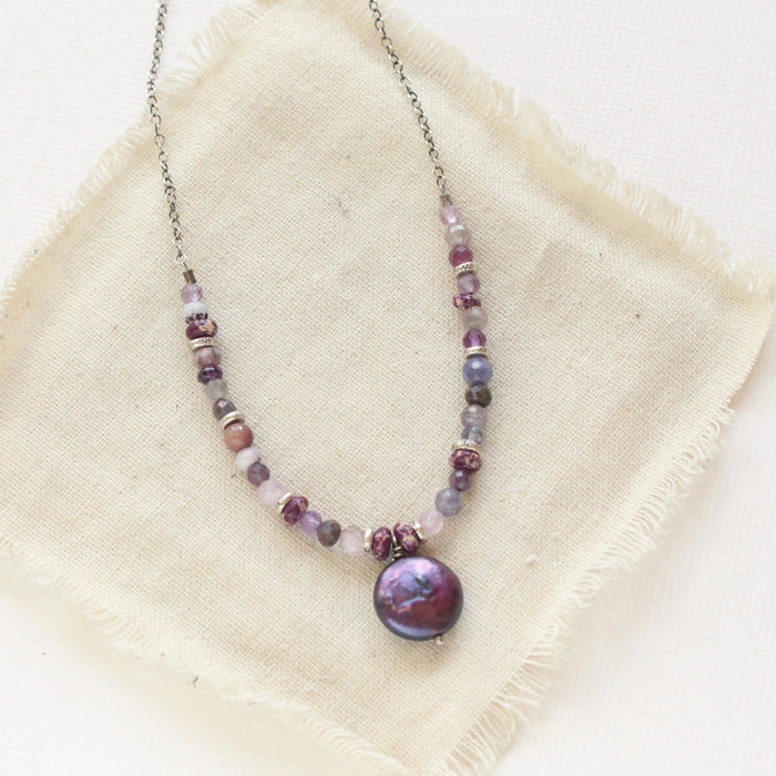 The purple rain necklace styled on tan linen