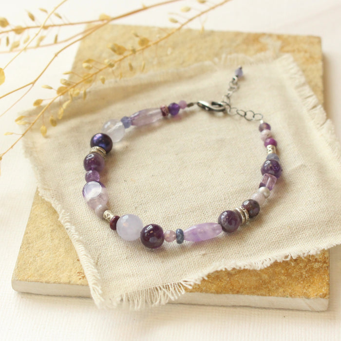 The purple rain gemstone bracelet styled on a tan rock