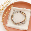 The rainbow agate sun bar double strand bracelet styled on an orange plate with linen and dried grass