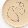 The rainbow agate sun rise charm necklace styled on a tan plate to show the adjustable lobster clasp closure