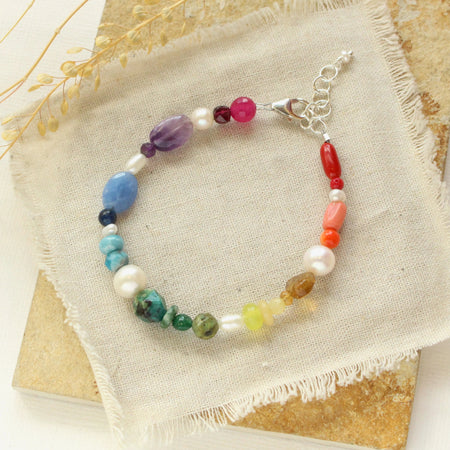 The rainbow bracelet styled on a tan rock with linen and dried grass