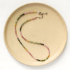 The rainbow tourmaline necklace styled on a tan plate to show the adjustable lobster clasp closure