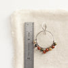 A jasper hoop earring styled next to a ruler for size reference