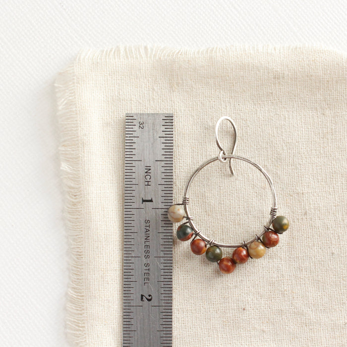 A jasper hoop earring styled next to a ruler for size reference