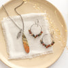 The jasper hoop earrings styled with the matching necklace on a tan plate with linen and dried grass