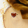The red jasper heart ring styled on wood with yellow velvet and dried grass
