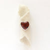 The red jasper heart ring styled on tan linen