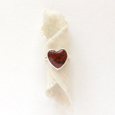 The red jasper heart ring styled on tan linen