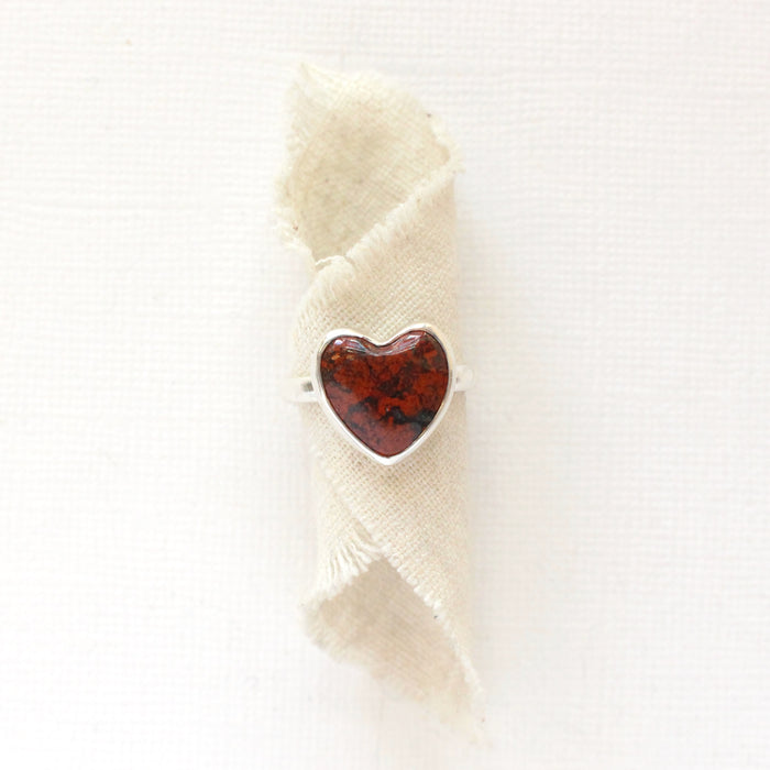 The red jasper heart ring styled on tan linen
