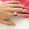 The rhodonite ring bring worn on a hand