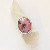 The rhodonite ring styled on rolled tan linen
