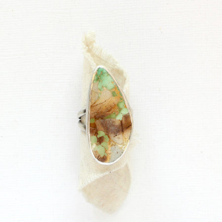 The stunning green and brown royston turquoise statement ring styled on rolled tan linen
