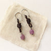 The ruby & leather earrings styled on tan linen