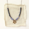 The bronze cactus flower vinca necklace styled on tan linen
