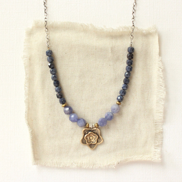 The bronze cactus flower vinca necklace styled on tan linen