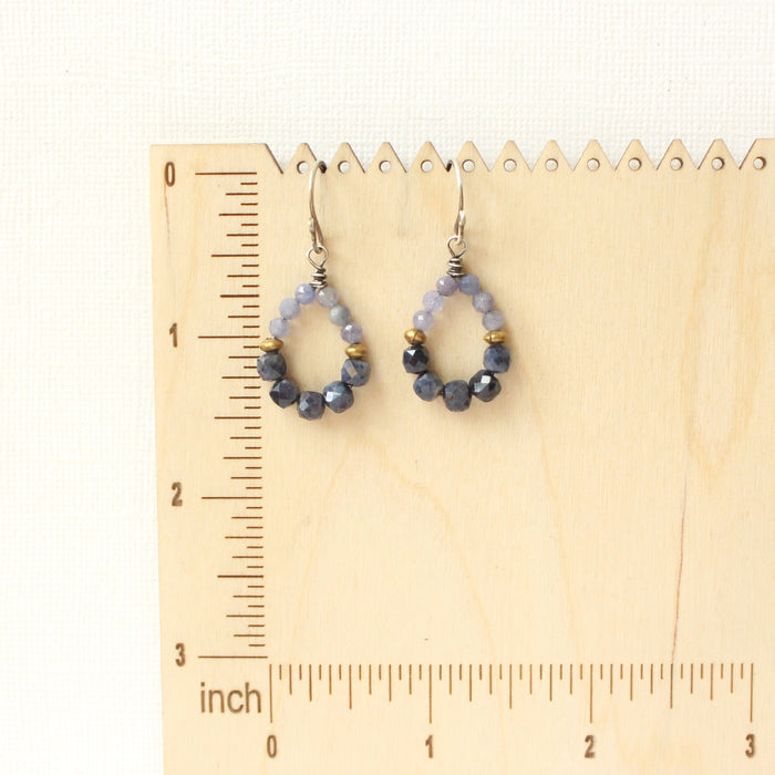 The vinca hoop earrings on a wooden ruler for size reference