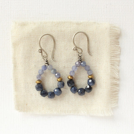The vinca hoop earrings styled on tan linen