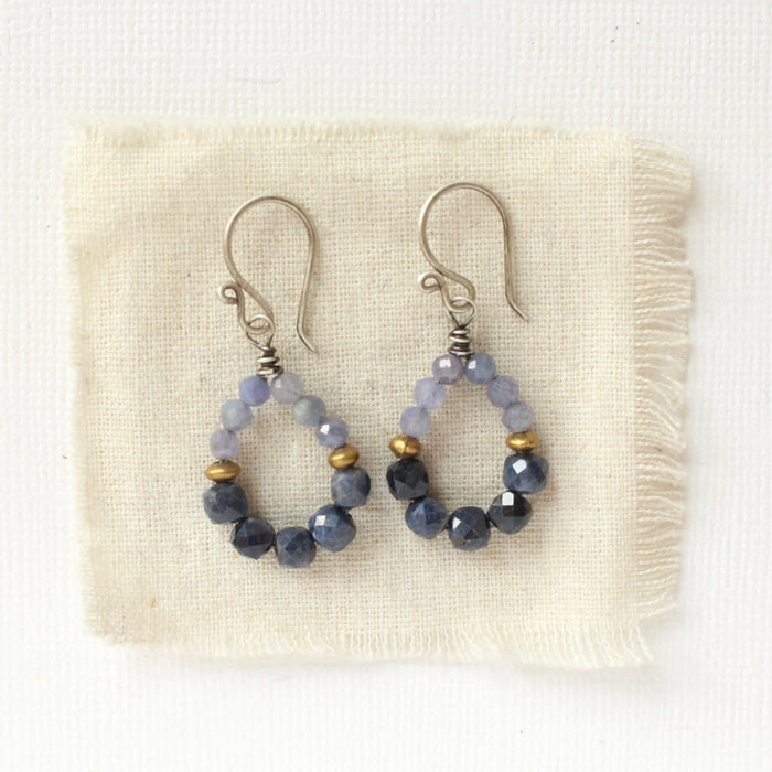 The vinca hoop earrings styled on tan linen