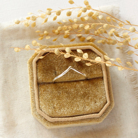 The silver momentum ring styled in a yellow velvet box with linen and dried grass